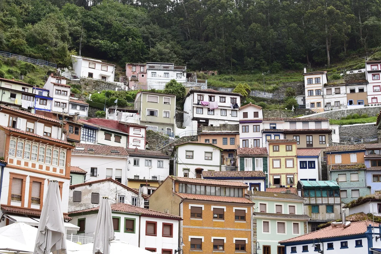 Casas tradicionales asturianas en una ladera, mostrando variados colores y diseños.